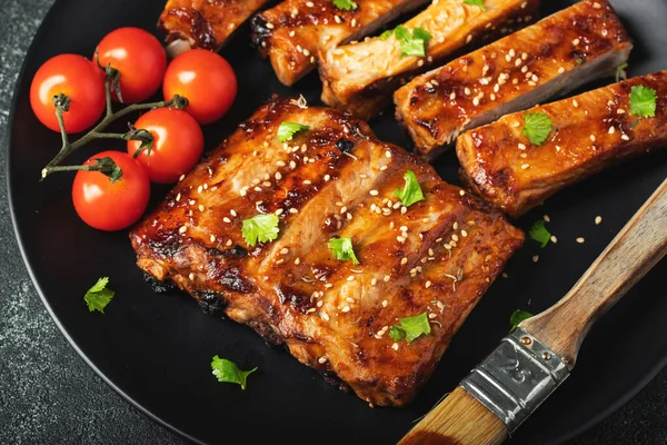 Barbekü soslu bir tabakta servis edilen sıcak ızgara pirzola. Üst Manzara. Boşluğu kopyala.