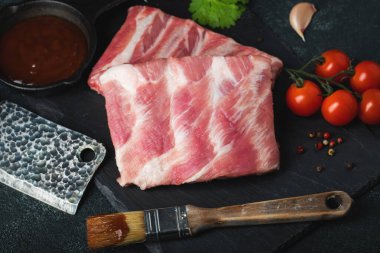 Çiğ et. Sırtından çiğ domuz kaburgası ve siyah bir arka planda et. arkaplan resmi, boşluk metni kopyala