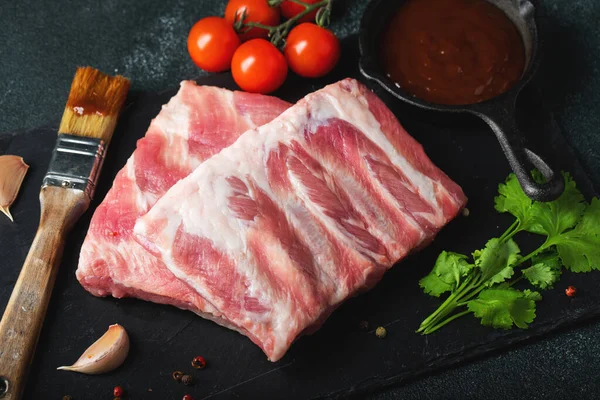 Çiğ et. Sırtından çiğ domuz kaburgası ve siyah bir arka planda et. arkaplan resmi, boşluk metni kopyala