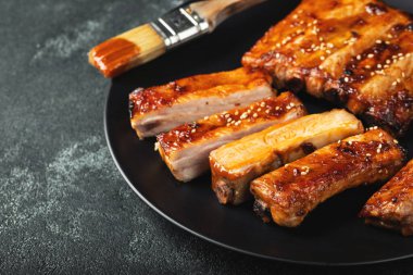 Barbekü soslu bir tabakta servis edilen sıcak ızgara pirzola. Üst Manzara. Boşluğu kopyala.