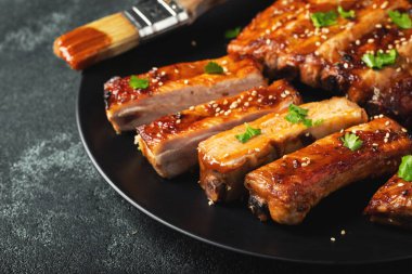 Barbekü soslu bir tabakta servis edilen sıcak ızgara pirzola. Üst Manzara. Boşluğu kopyala.