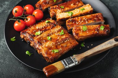 Barbekü soslu bir tabakta servis edilen sıcak ızgara pirzola. Üst Manzara. Boşluğu kopyala.