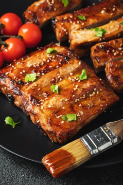 Barbekü soslu bir tabakta servis edilen sıcak ızgara pirzola. Üst Manzara. Boşluğu kopyala.