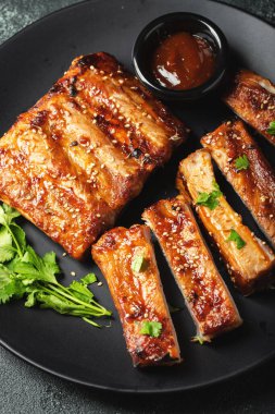 Barbekü soslu bir tabakta servis edilen sıcak ızgara pirzola. Üst Manzara. Boşluğu kopyala.