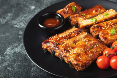 Barbekü soslu bir tabakta servis edilen sıcak ızgara pirzola. Üst Manzara. Boşluğu kopyala.