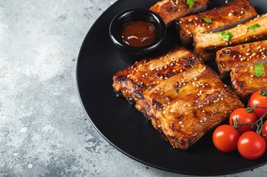 Barbekü soslu ızgara domuz pirzolası ve balda karamelize edilmiş. Hafif beton arka planda dosyalama yapmak için ahşap bir tahtada biraya lezzetli atıştırmalıklar. Kopyalama alanı olan üst görünüm.