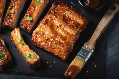 Barbekü domuz pirzolası ve siyah arka planda sıcak bal biberli terbiye..