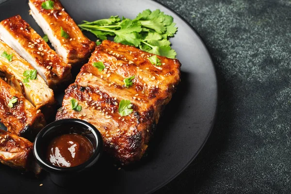 Barbekü soslu bir tabakta servis edilen sıcak ızgara pirzola. Üst Manzara. Boşluğu kopyala.