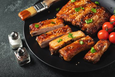 Barbekü soslu bir tabakta servis edilen sıcak ızgara pirzola. Üst Manzara. Boşluğu kopyala.