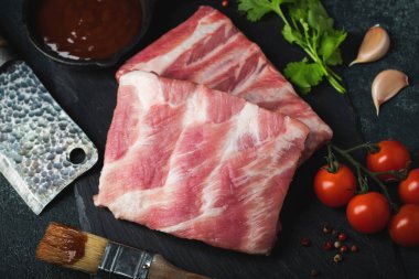 Çiğ et. Sırtından çiğ domuz kaburgası ve siyah bir arka planda et. arkaplan resmi, boşluk metni kopyala