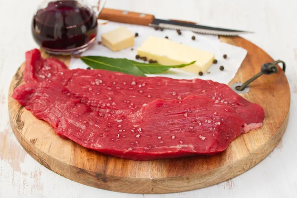 Rauw rundvlees met boter, kruiden en zwarte peper — Stockfoto
