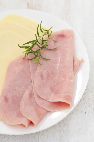 Schinken mit Käse auf weißem Teller auf weißem Holzhintergrund — Stockfoto