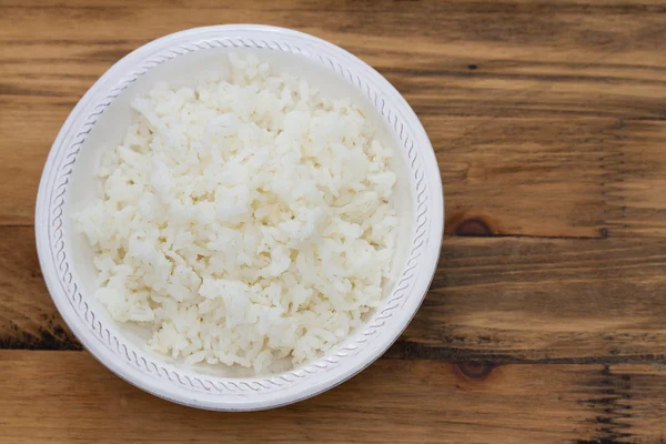 Arroz hervido en un tazón blanco sobre fondo marrón —  Fotos de Stock