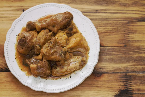 Gekookte kip met saus van bier in witte plaat — Stockfoto