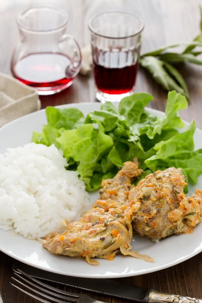 Lapin avec riz bouilli et salade sur assiette blanche — Photo