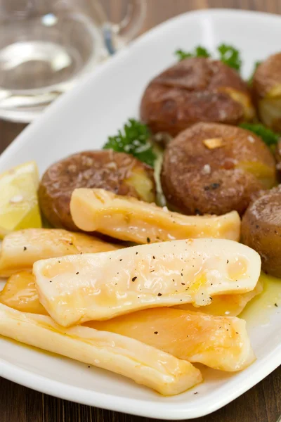 Bläckfisk med potatis på vita skålen — Stockfoto