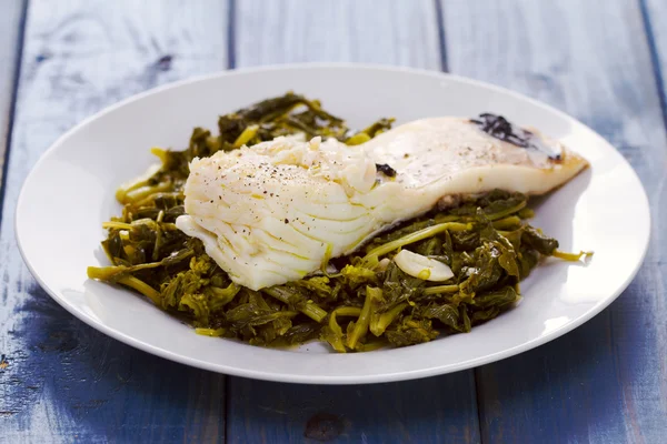 Bacalao con hojas de nabo en plato blanco — Foto de Stock