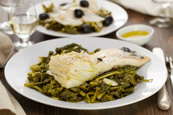 Баклажаны с оливками и зеленью на белой тарелке — стоковое фото