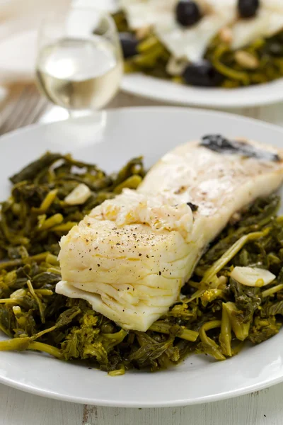 Bacalao con aceitunas y verduras en plato blanco — Foto de Stock