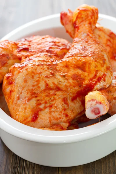 Marinated chicken legs on white dish — Stock Photo, Image