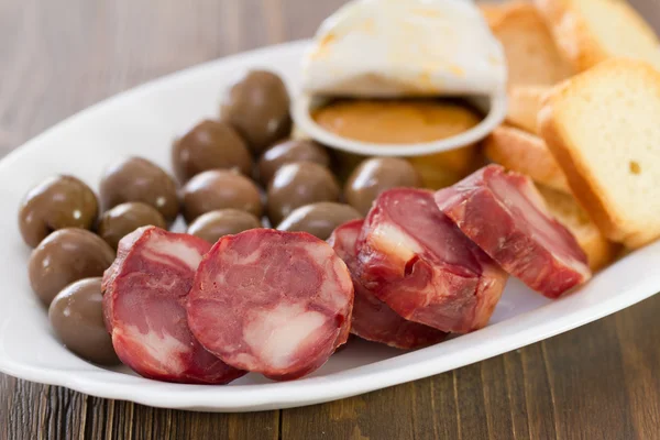 Toasts with smoked sausages, pate and olives — Stock Photo, Image