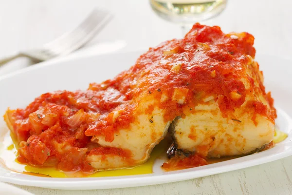 Cod fish with tomato sauce on white dish — Stock Photo, Image