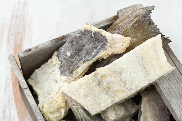 Pescado de bacalao salado en caja de madera sobre fondo blanco — Foto de Stock