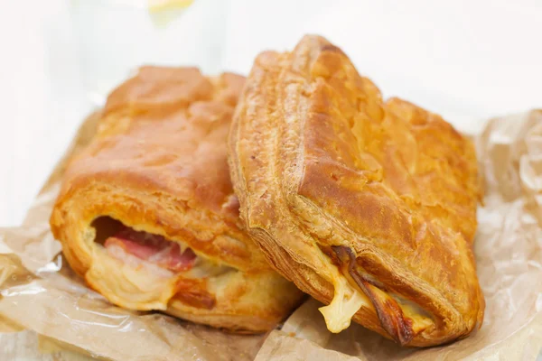 Pie with ham and cheese with glass of water — Stock Photo, Image