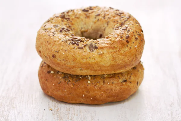 Fresh bagels on white wooden background — Stock Photo, Image