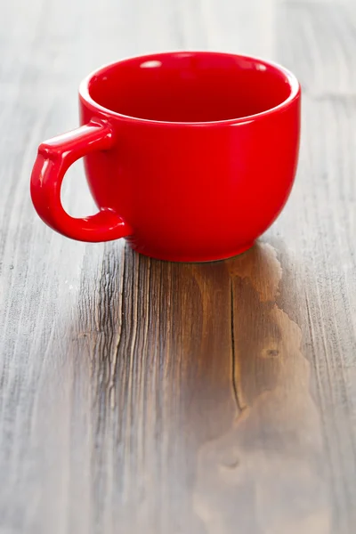 Taza de cerámica roja vacía sobre fondo de madera marrón — Foto de Stock