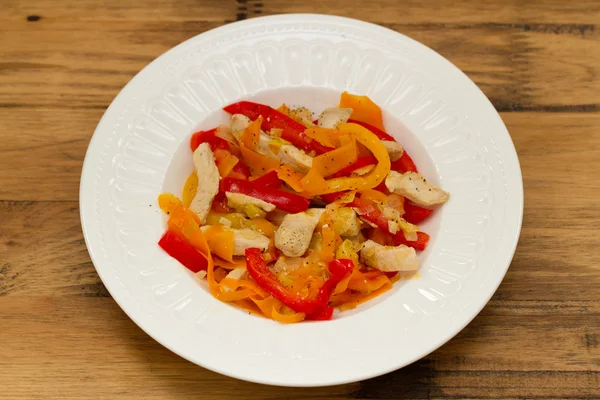 Курица с овощами на белой тарелке — стоковое фото