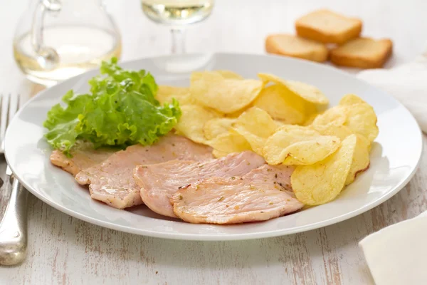 fried meat with chips and fresh lettuce