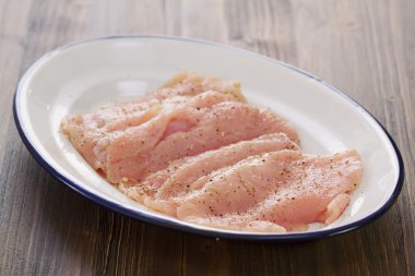 Kahverengi ahşap arka planda beyaz tabakta çiğ et