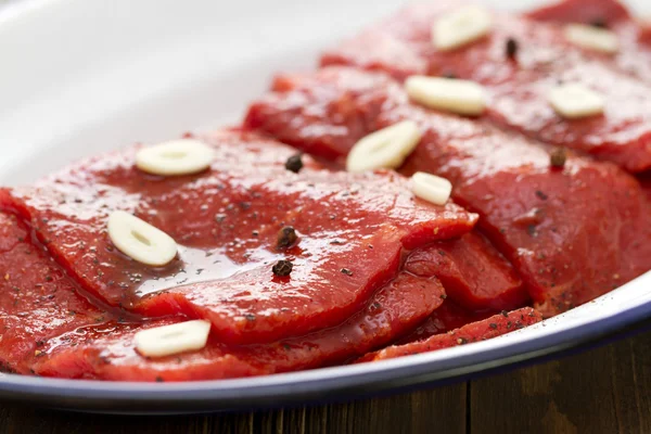 Carne con salsa y ajo en plato blanco — Foto de Stock
