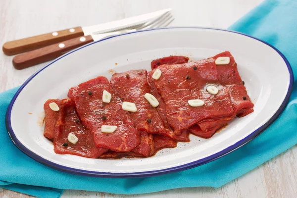 Carne con salsa e aglio su piatto bianco — Foto Stock