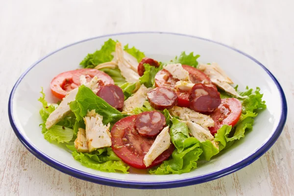 Fresh salad with chicken and chourico on white dish — Stock Photo, Image