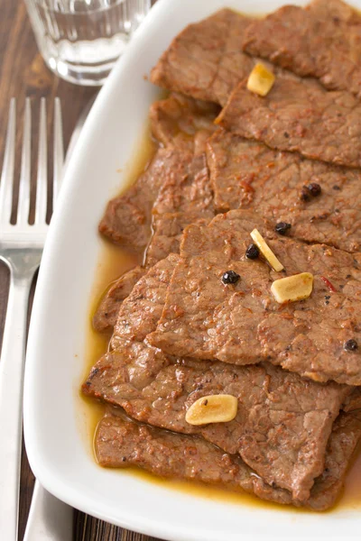 Gebratenes Fleisch mit Sauce auf weißem Teller — Stockfoto