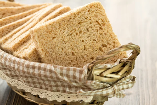 Chleb w koszyku na brązowym tle drewnianych — Zdjęcie stockowe
