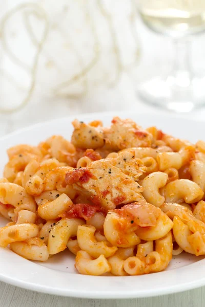 Pasta with fish on white plate and glass of wine — Stock Photo, Image