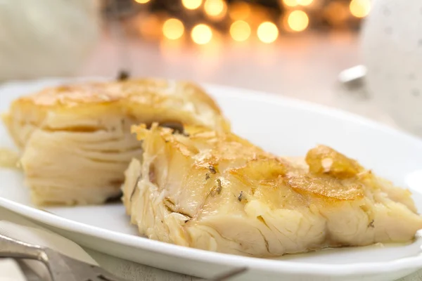 Bacalhau frito na placa branca no fundo de madeira branco — Fotografia de Stock