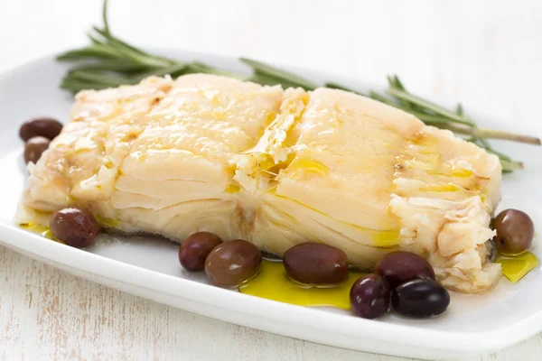 Boiled cod fish with olives — Stock Photo, Image