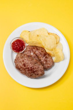 Domates soslu kızarmış et ve patates cipsi.