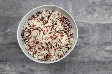 Seramik arka plandaki kasede üç çeşit pilav var.