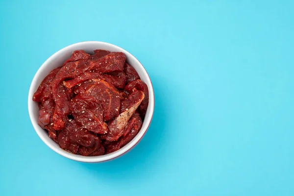 Marinerat rått kött med kryddor i röd och vit skål — Stockfoto