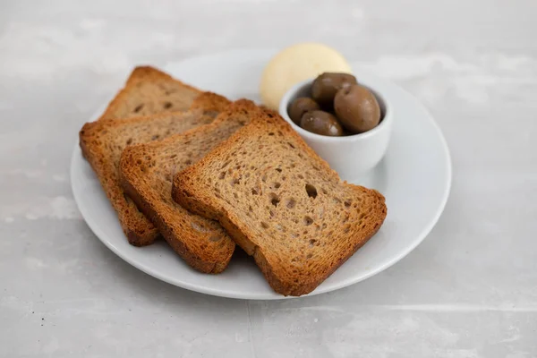 Rostat bröd med ost på vit liten tallrik — Stockfoto