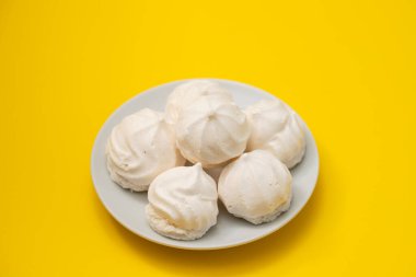 Beyaz tabakta küçük beyaz kremalar