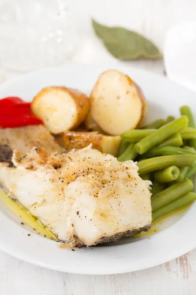 Pesce con verdure su piatto bianco — Foto Stock