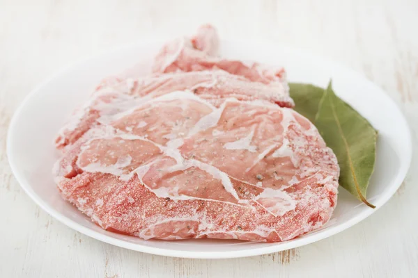 Carne di maiale congelata sul piatto — Foto Stock