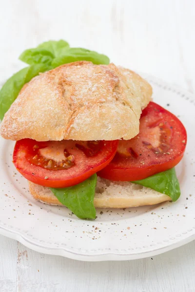 Бутерброд з помідорами і базиліком на тарілці — стокове фото