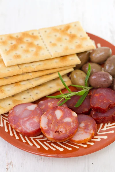 Chourico with olives on dish — Stock Photo, Image